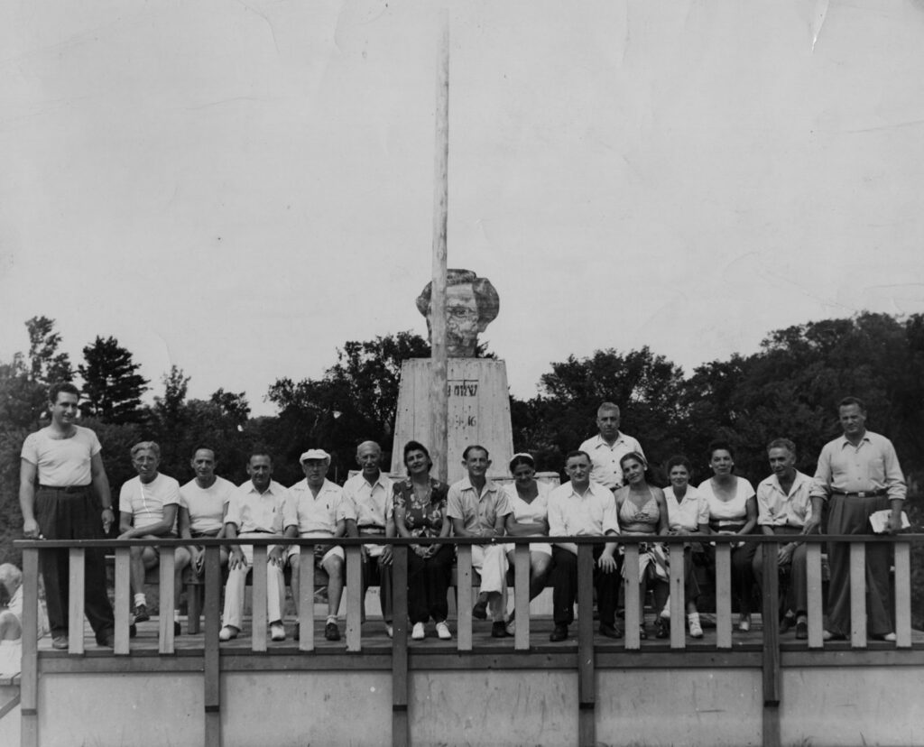 Members of the Camp Naivelt committee gather in front of a monument to Sholom Aleichem designed by Naivelter Avrom Yanovsky (photo courtesy Ontario Jewish Archives)