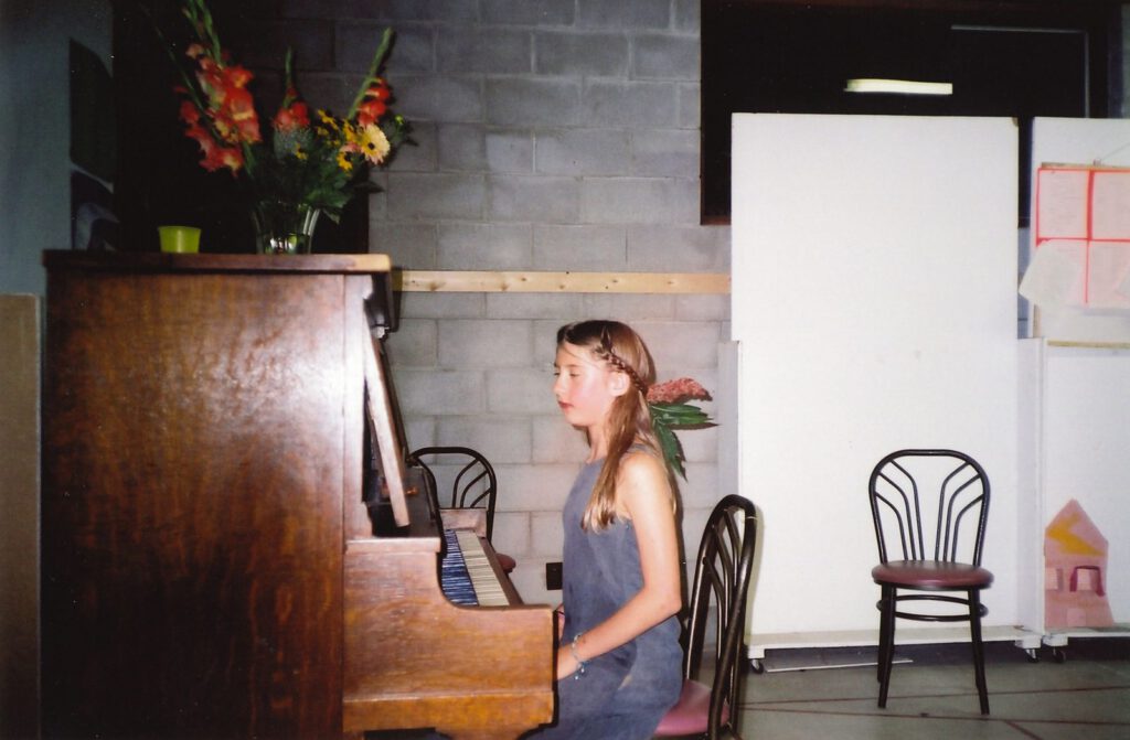 A young Naivelter plays piano during a Camp performance