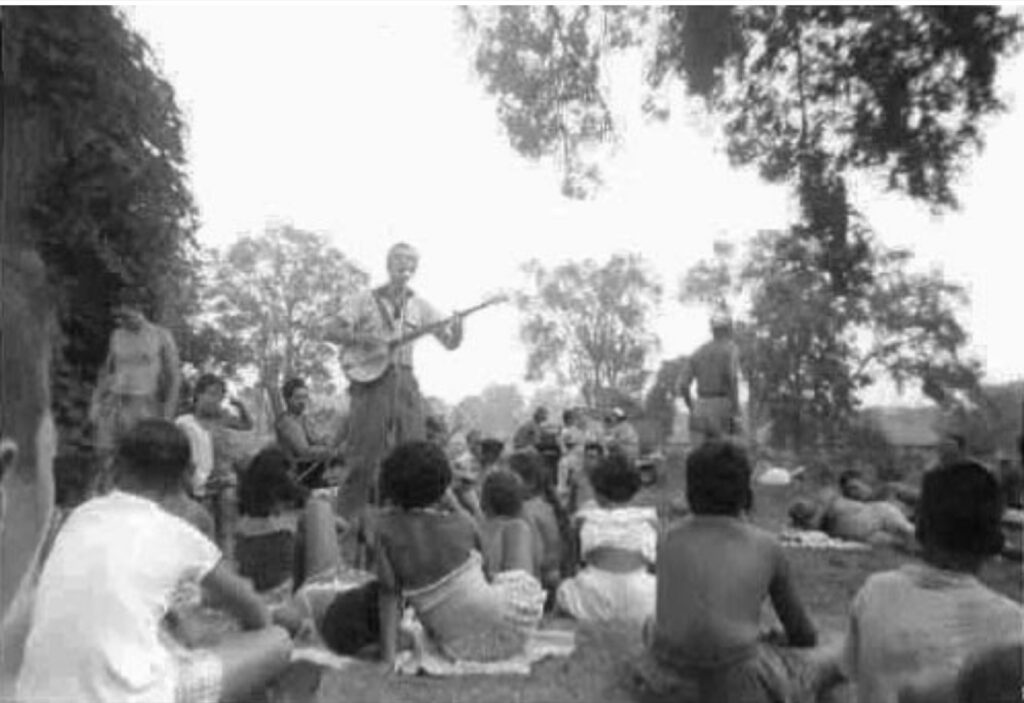 Pete Seeger would become a regular visitor to Camp Naivelt. Here, he gives an outdoor concert for a community gathering. (Photo by Barbara Blaser)