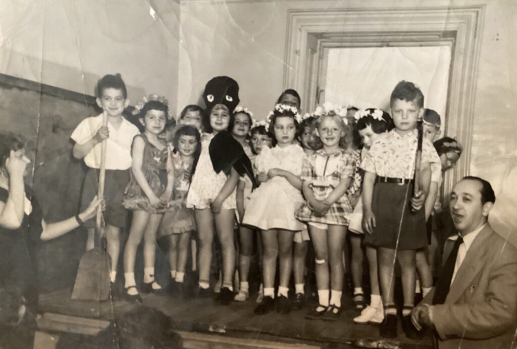MWS Montreal students gather on stage in the early fifties while their principal, renowned Yiddish poet Sholom Shtern, accompanies them on piano